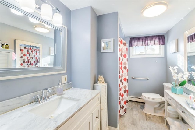 bathroom with vanity, wood-type flooring, toilet, and a baseboard radiator