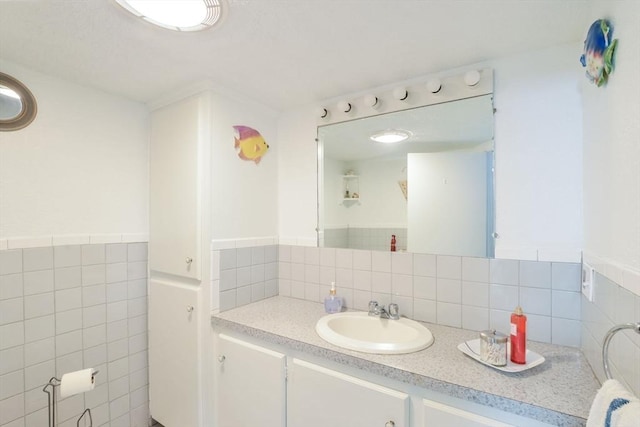 bathroom featuring vanity and tile walls