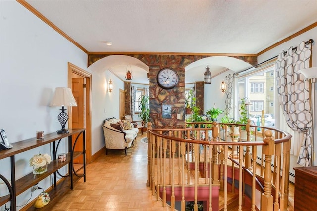 hallway featuring a textured ceiling, ornamental molding, and light parquet floors