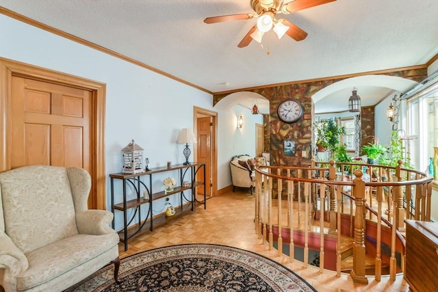 living area with crown molding, a textured ceiling, and light parquet floors