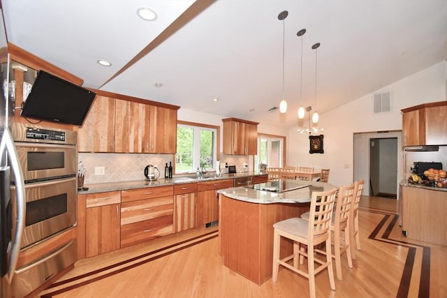 166 Primrose Dr, Longmeadow, MA 01106 - kitchen featuring appliances with stainless steel finishes, a warming drawer, vaulted ceiling, a kitchen island, and light wood-style floors