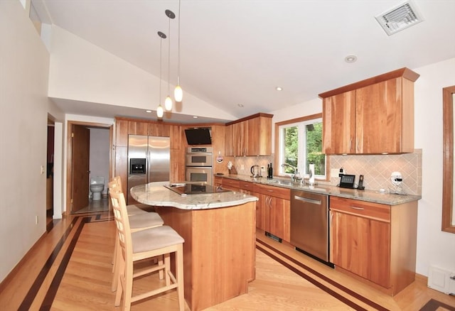 166 Primrose Dr, Longmeadow, MA 01106 - kitchen featuring stainless steel appliances, lofted ceiling, light wood-type flooring, a center island, and tasteful backsplash