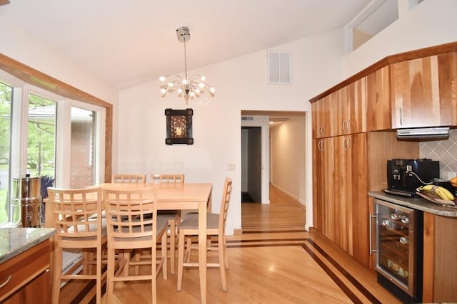 166 Primrose Dr, Longmeadow, MA 01106 - dining area featuring wine cooler, lofted ceiling, light wood finished floors, a chandelier, and bar