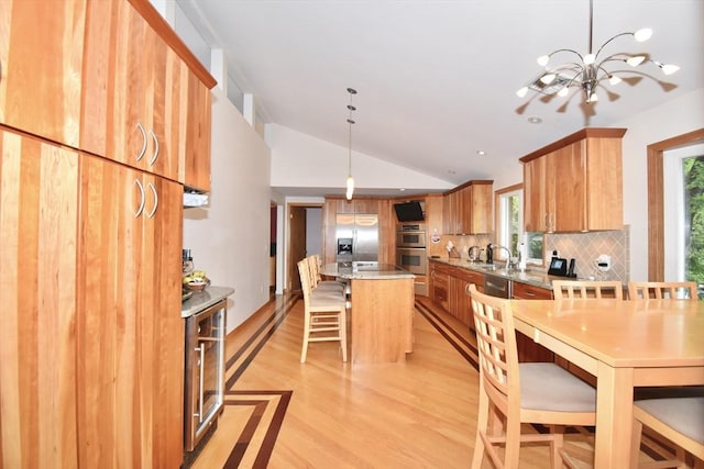166 Primrose Dr, Longmeadow, MA 01106 - kitchen with lofted ceiling, stainless steel appliances, a breakfast bar, healthy amount of natural light, and tasteful backsplash