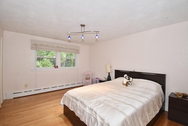 166 Primrose Dr, Longmeadow, MA 01106 - bedroom with a baseboard heating unit and wood finished floors