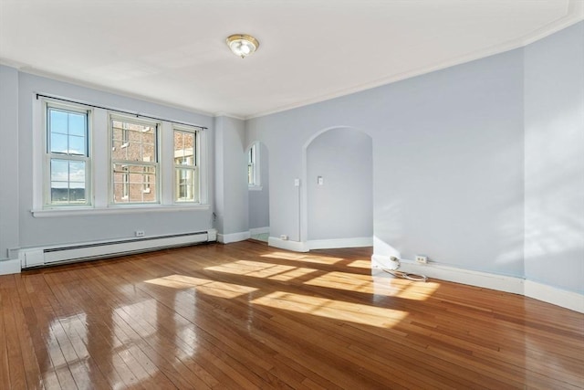 empty room with arched walkways, baseboards, light wood-style flooring, ornamental molding, and baseboard heating