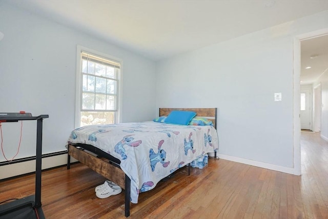 bedroom featuring recessed lighting, baseboards, hardwood / wood-style flooring, and baseboard heating