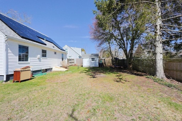 view of yard featuring a fenced backyard, a storage unit, and an outbuilding