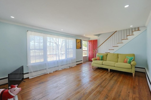living area with a baseboard heating unit, recessed lighting, wood finished floors, stairway, and ornamental molding