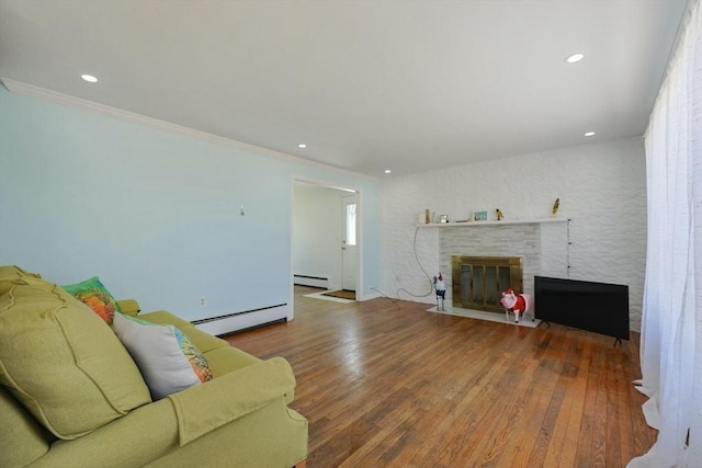 living room with recessed lighting, wood finished floors, a brick fireplace, and baseboard heating