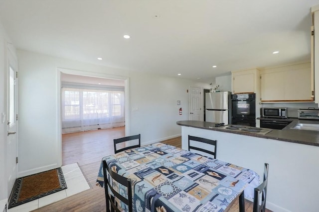 dining room with baseboards, wood finished floors, recessed lighting, and a toaster