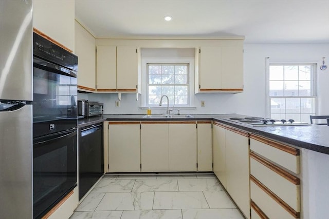 kitchen with marble finish floor, a healthy amount of sunlight, black appliances, and a sink