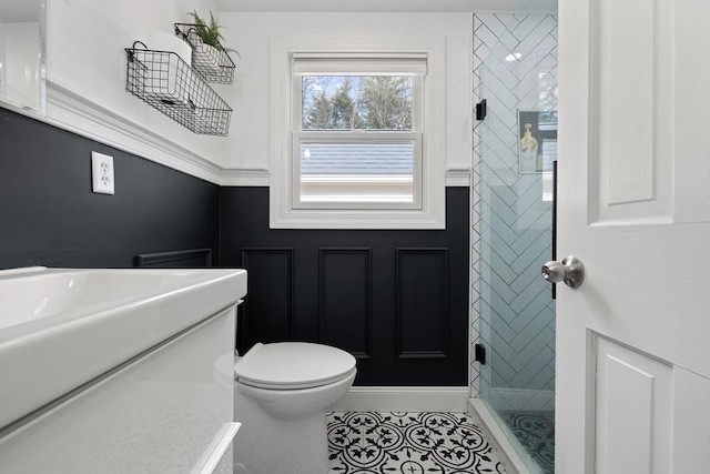 bathroom with tile patterned floors, toilet, vanity, and a stall shower