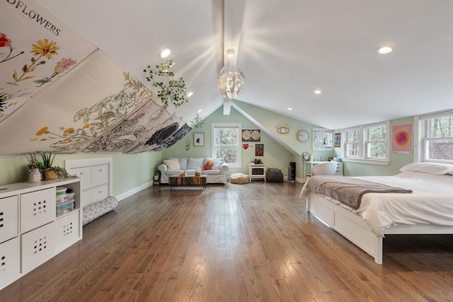 bedroom with wood finished floors, baseboards, multiple windows, and lofted ceiling