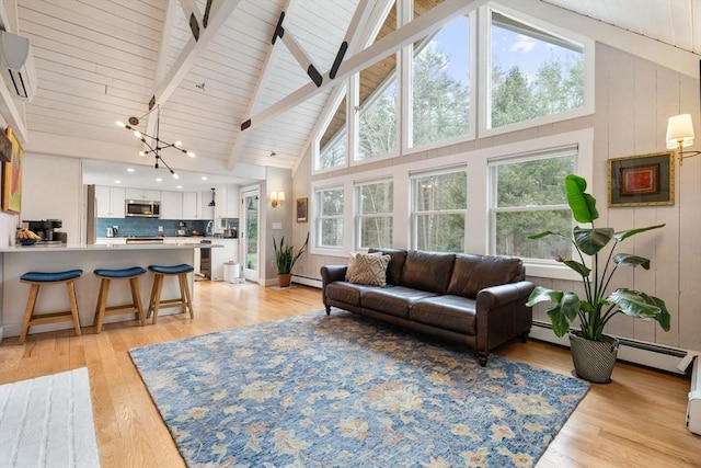 living room with a wall mounted AC, baseboard heating, a chandelier, beamed ceiling, and light wood finished floors