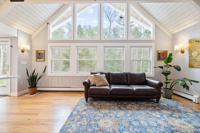 living room with a wealth of natural light, a baseboard radiator, and wood finished floors