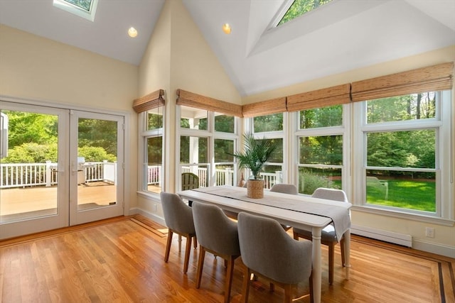 sunroom / solarium with french doors, a skylight, high vaulted ceiling, baseboards, and baseboard heating