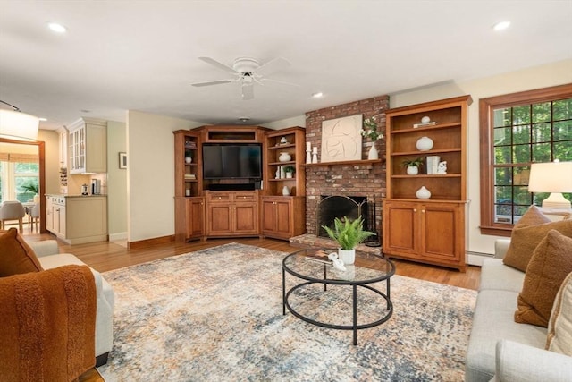 living area featuring healthy amount of natural light, ceiling fan, light wood-style floors, and recessed lighting