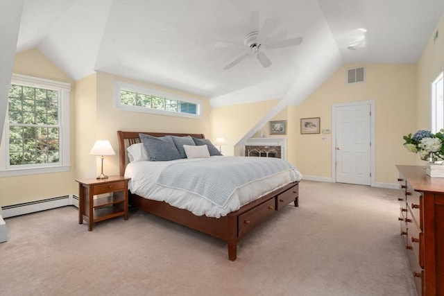 bedroom featuring a baseboard heating unit, vaulted ceiling, multiple windows, and light colored carpet