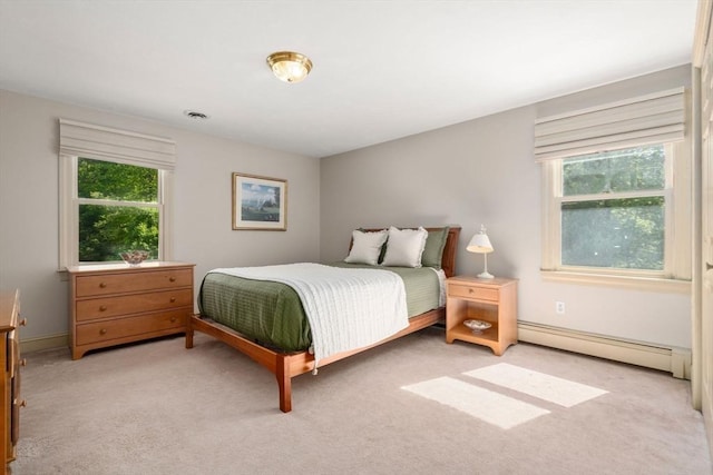 bedroom featuring baseboard heating and light carpet