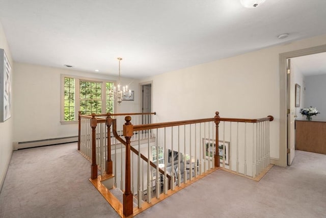hallway with a baseboard heating unit, an upstairs landing, carpet flooring, and a chandelier