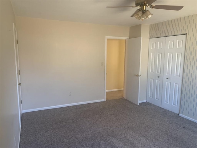 unfurnished bedroom featuring baseboards, wallpapered walls, ceiling fan, a closet, and carpet flooring