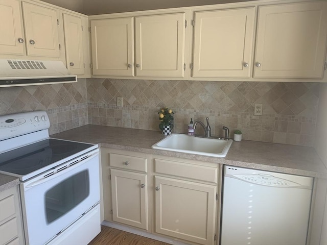 kitchen featuring backsplash, ventilation hood, light countertops, white appliances, and a sink