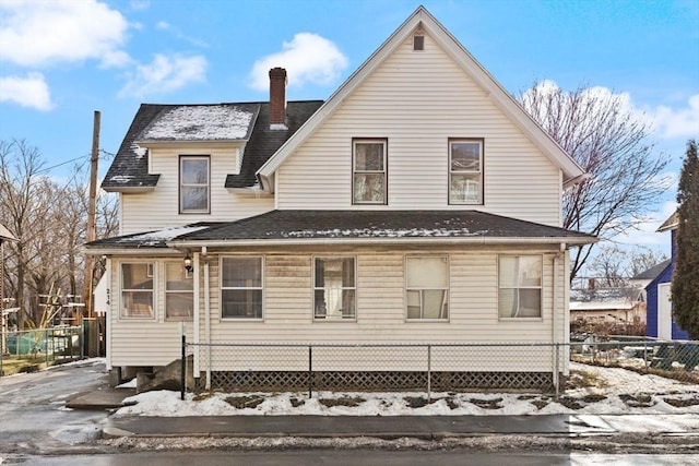 view of snow covered back of property