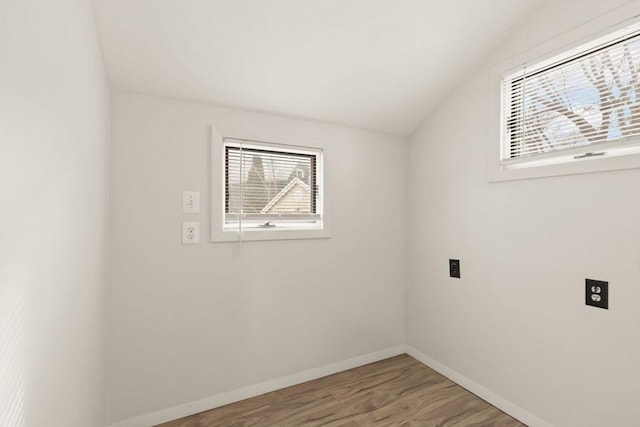 spare room featuring hardwood / wood-style flooring and vaulted ceiling