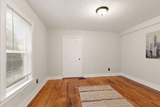 empty room featuring hardwood / wood-style flooring and a textured ceiling