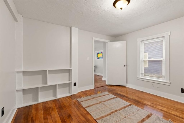 spare room with hardwood / wood-style flooring and a textured ceiling