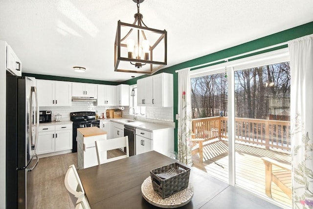 dining space with an inviting chandelier, light wood finished floors, and a textured ceiling