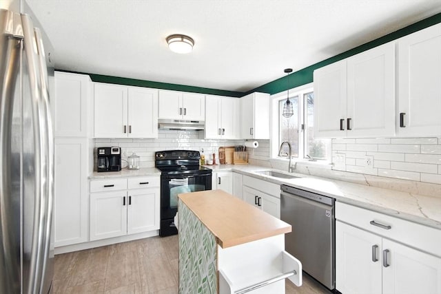 kitchen featuring a sink, stainless steel appliances, under cabinet range hood, white cabinetry, and tasteful backsplash