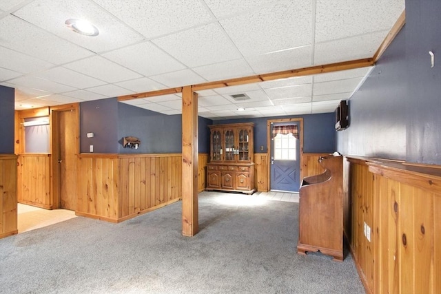 interior space with a wainscoted wall, carpet flooring, and visible vents