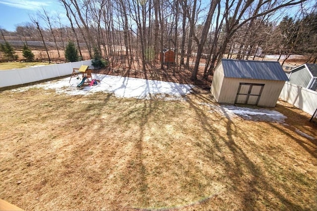 view of yard featuring fence, an outdoor structure, and a shed