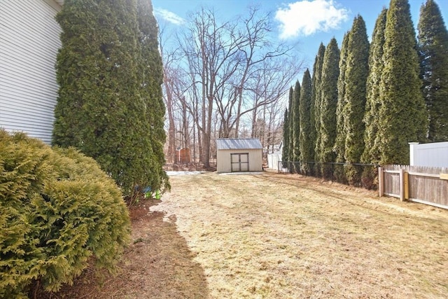 view of yard featuring a storage unit, an outdoor structure, and fence