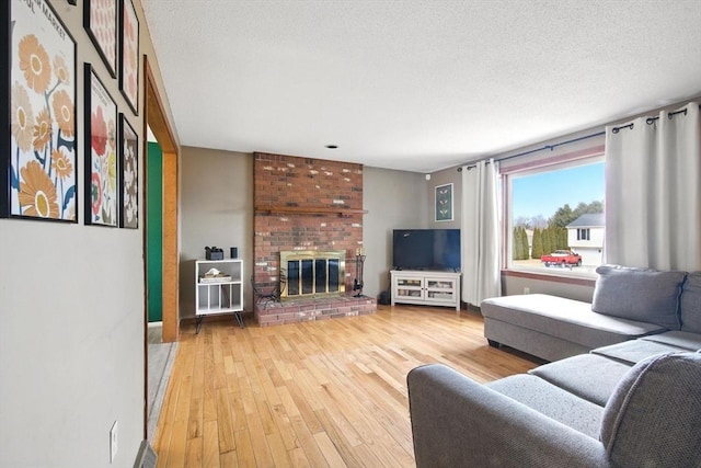 living room with visible vents, wood-type flooring, a textured ceiling, and a fireplace