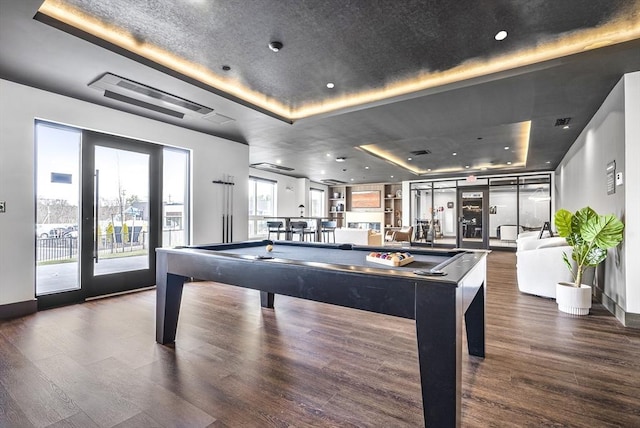 game room with a raised ceiling, a textured ceiling, wood finished floors, pool table, and baseboards