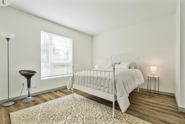 bedroom with baseboards and wood finished floors