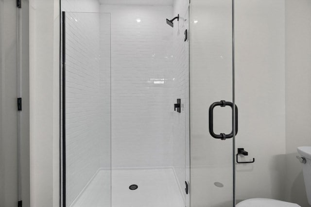 bathroom with a stall shower and toilet