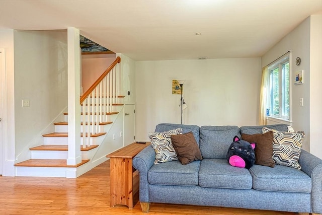 living area featuring wood finished floors and stairway