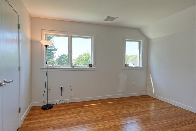 bonus room featuring light wood finished floors, baseboards, and lofted ceiling