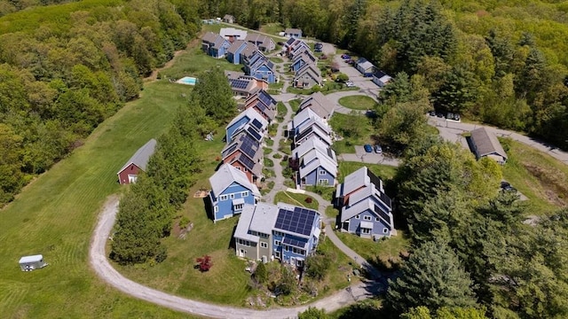 aerial view of property's location featuring a forest and nearby suburban area