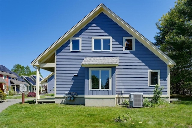 back of property with central AC unit and a lawn