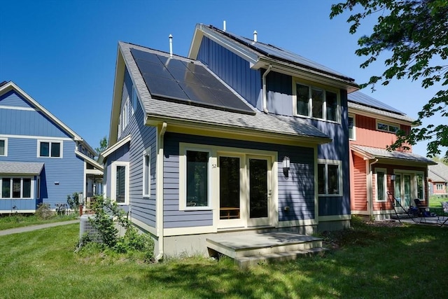back of property with solar panels, a lawn, and central AC