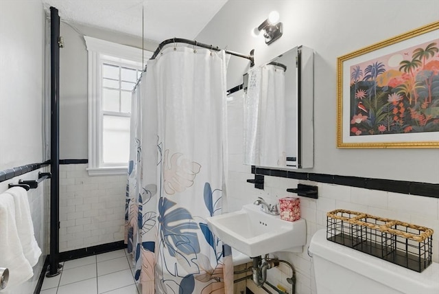 72 Strathmore Rd Unit 10B, Boston, MA 02135 - bathroom featuring tile walls, toilet, a wainscoted wall, tile patterned flooring, and a shower with curtain