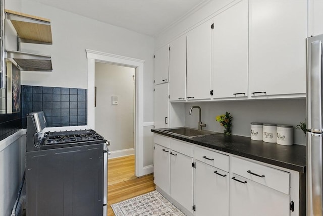 72 Strathmore Rd Unit 10B, Boston, MA 02135 - kitchen with gas range oven, a sink, dark countertops, white cabinetry, and light wood finished floors