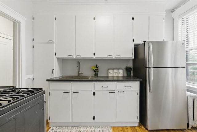 72 Strathmore Rd Unit 10B, Boston, MA 02135 - kitchen with freestanding refrigerator, a sink, white cabinetry, radiator heating unit, and dark countertops
