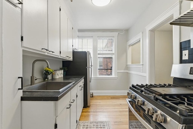 72 Strathmore Rd Unit 10B, Boston, MA 02135 - kitchen featuring stainless steel appliances, a sink, white cabinets, dark countertops, and light wood-style floors
