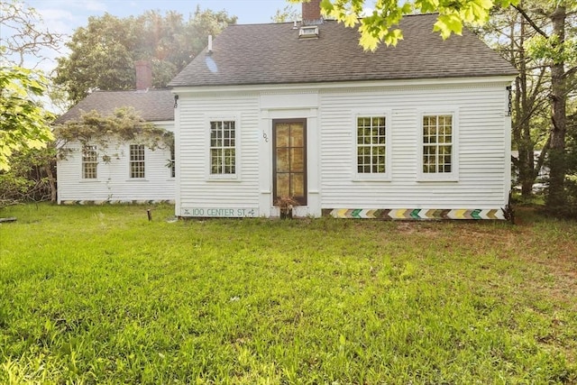 100 Center St, Dennis, MA 02660 - back of house featuring a chimney, a yard, and roof with shingles